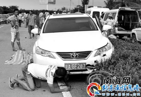 當時坐在車里的一名男士,在觀看車是否撞壞,而輪胎邊上放著環衛工人的尸體。記者 劉孫謀 攝