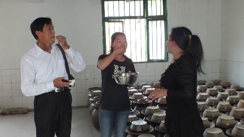 圖為丁希光查看車間內(nèi)的水鹽菜