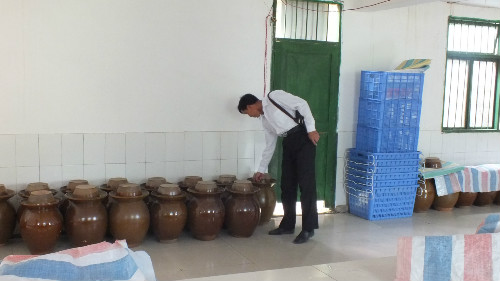 圖為丁希光查看車間內(nèi)的水鹽菜