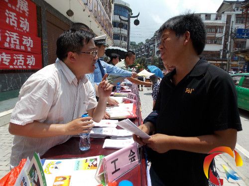 圖為工作人員為咨詢者解讀宣傳資料