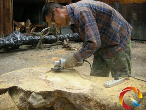 田錦林正在對樹根打磨