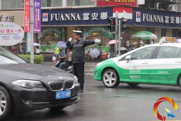 風雨中堅毅的警徽——凱里交警冒雨疏導交通(圖)