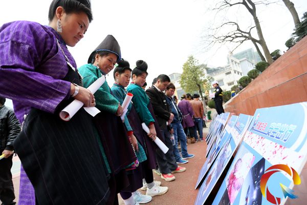 幾名苗族村民在觀看交通警示宣傳牌