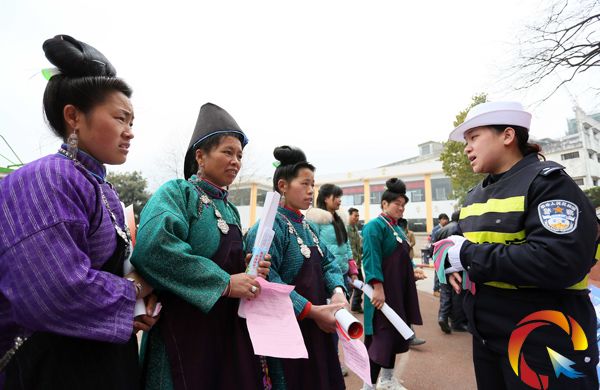 一名交警宣傳員向苗族村民講解高速公路交通安全要領