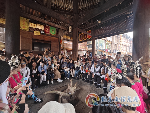 游客和侗族人民圍坐在鼓樓前一起唱侗歌