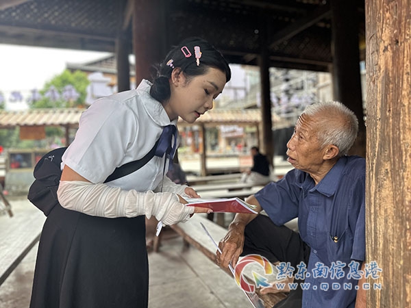 圖為:宣傳人員用侗語向老年群眾宣傳民法典知識